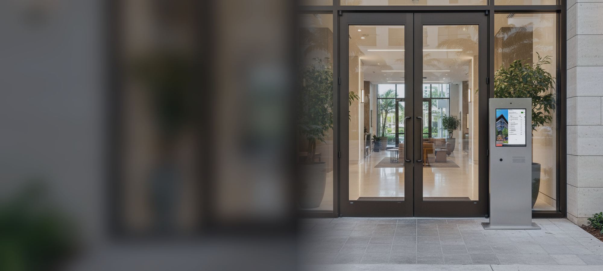 Condoplex pedestal entry kiosk beside a building lobby entrance
